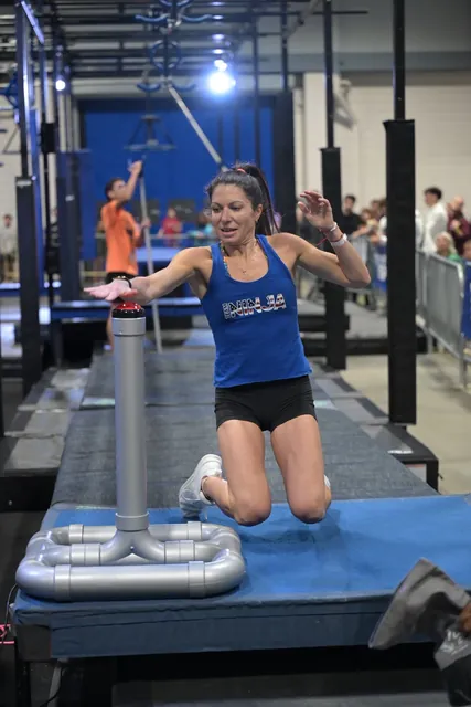Ashley Kiser landing on a platform with her arms out
