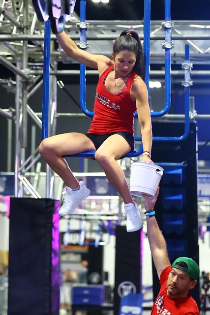 Ashley Kiser hanging from a bar with her knees raised