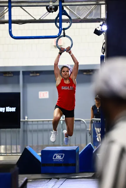 Ashley Kiser hanging from a pair of rings