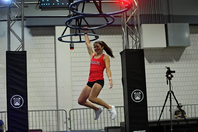 Ashley Kiser swinging from a ring obstacle