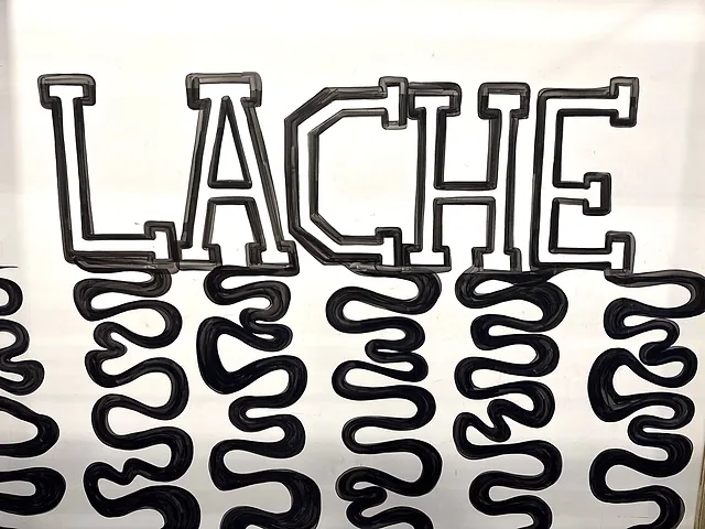 The word LACHE hand-lettered in black on a white wall, with wavy black lines dripping down from each letter
