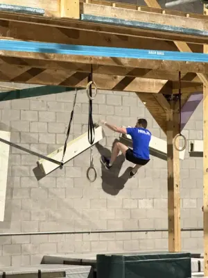 Nicholas Parker in a blue NinjaFit shirt jumping between angled boards
