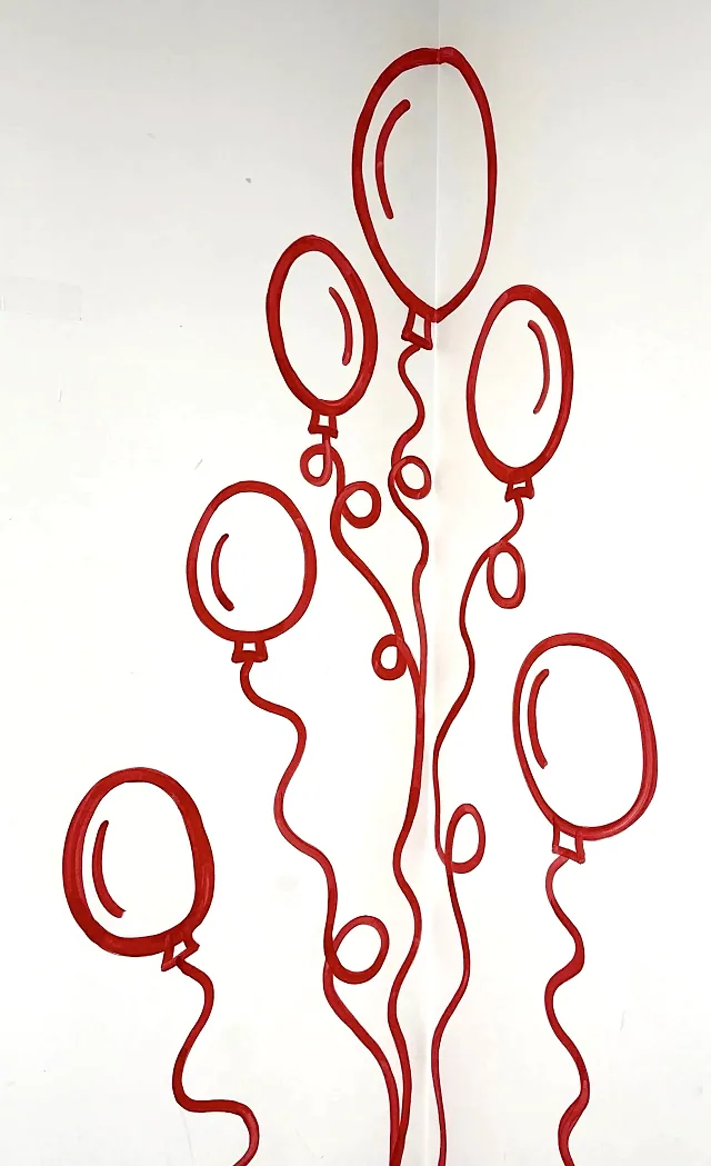 Red balloons hand-painted on the corner of the party room wall