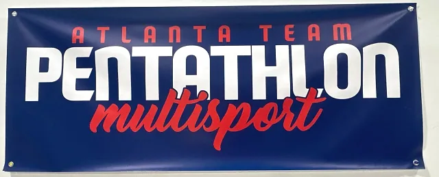 A blue banner on the gym wall that reads Atlanta Team Pentathlon Multisport
