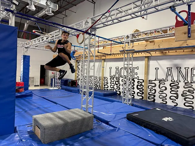 Coach Aiden Burley flying between rings on the lache course