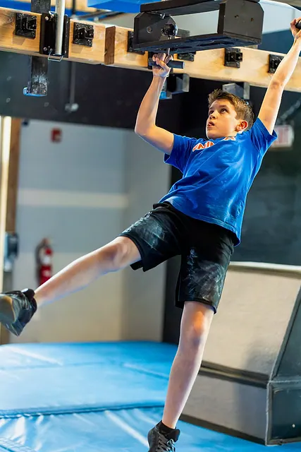 Coach Jackson McGee on a hanging grip obstacle