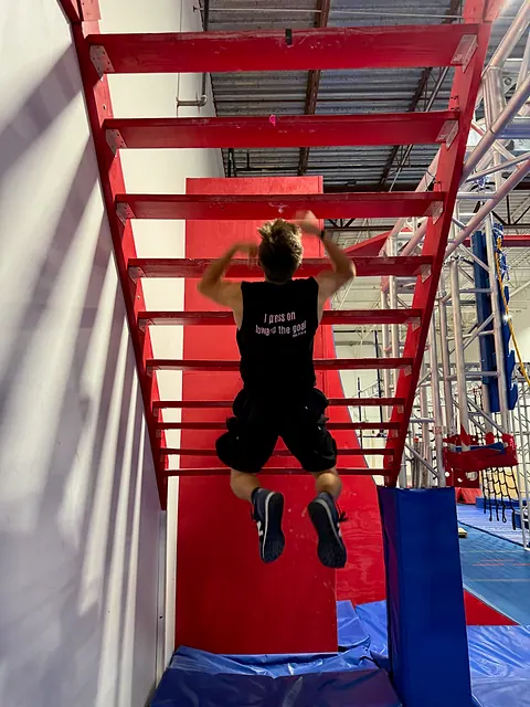Coach Aiden Burley on the salmon ladder, wearing the Press On tee