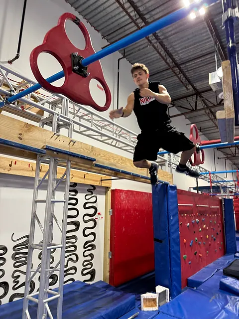Coach Aiden Burley leaping toward the spinning wheels